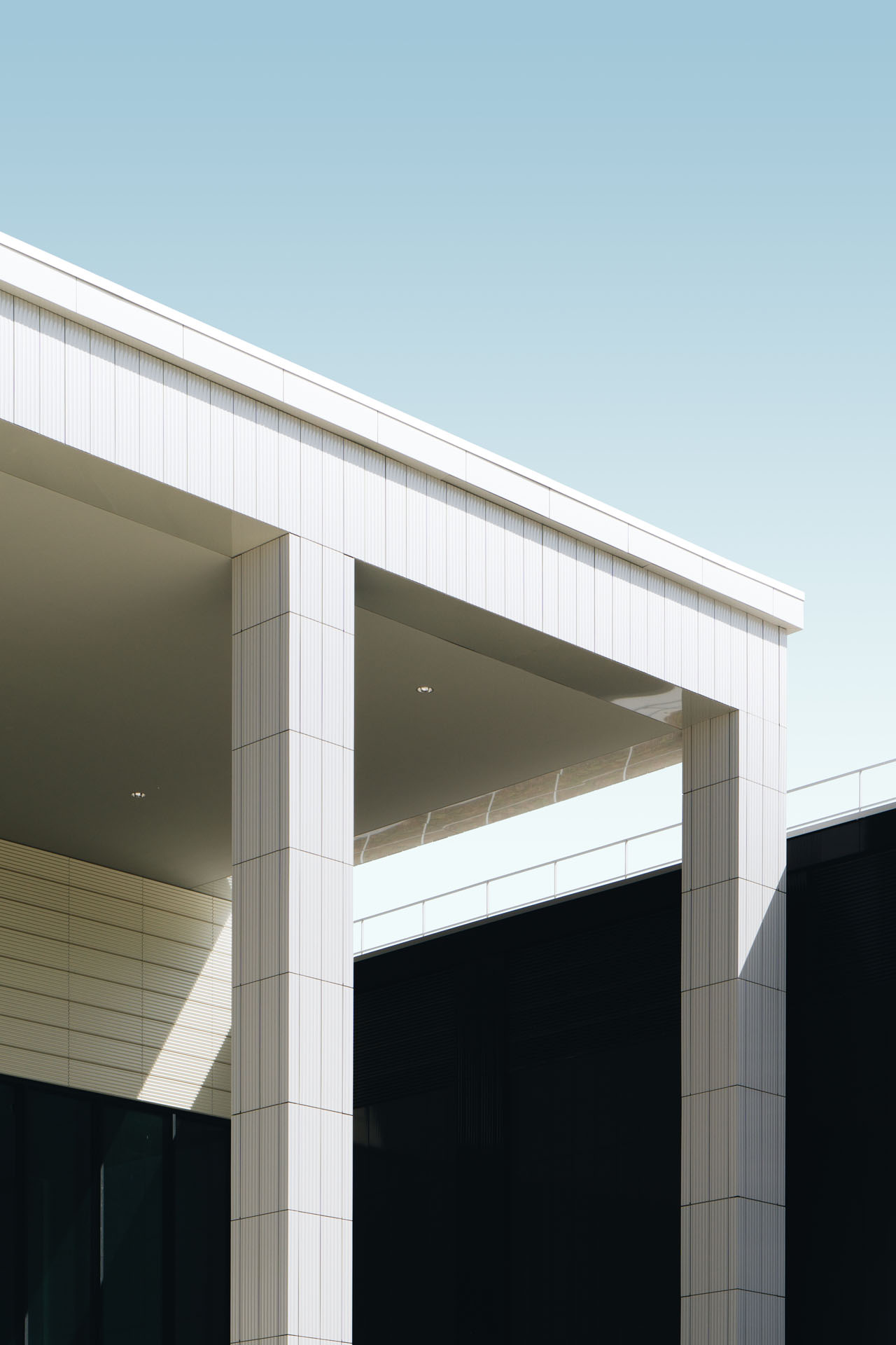 Latitude 31 Construction Solutions Corfu photo from a vertical low angle shot of a white tiled building under the blue sky